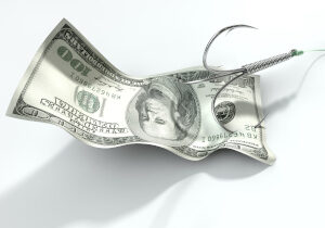 A concept image showing a one hundred dollar banknote used as bait attached to a treble fishhook and fishing line on an isolated white background